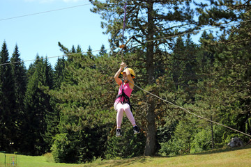 Little girl sliding on a zip line