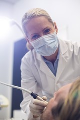 Naklejka premium Dentist examining a patient with tool