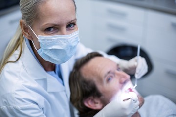 Dentist examining a patient with tools