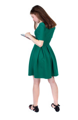 back view of standing young beautiful  woman using a mobile phone or tablet computer. girl  watching. Rear view people collection.  backside view of person.  Isolated over white background. The