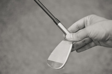 Black white picture of golf club in hand, copyspace background