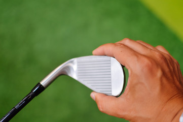 Hand holding golf club, close up
