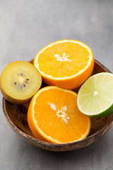 Mixed citrus fruit lemons, orange, kiwi, limes on a gray backgro