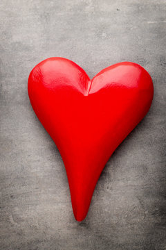 Red heart on the gray metal background.