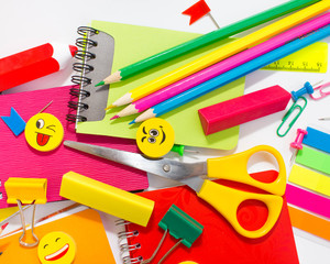 Pens, pencils, erasers, with smileys and a set of notebooks. Schoolchild and student studies accessories. Back to school concept.
