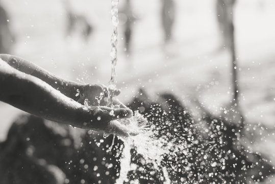 Black white image of happy child holding hands in water. Summer outdoors background