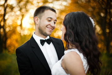 Happy groom admires a beautiful curly bride