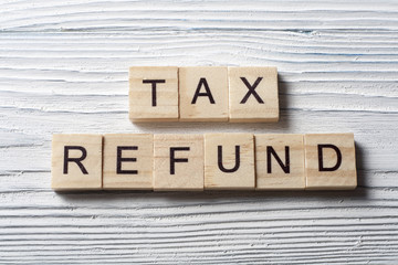 tax refund text on wooden cubes. wood abc at table