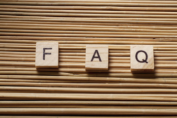 FAQ word written on wood block. Wooden ABC.