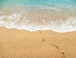 Fototapeta na wymiar footprints on sand and turquoise sea water