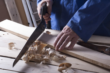 Carpenter working with plane on wooden background at Building Site. Joiner workplace