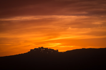Village of Sant' Antonino in Corsica silhoutted against orange e