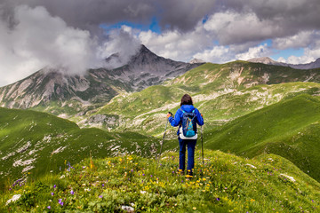 Fototapeta premium woman traveling on alpine meadow plateau