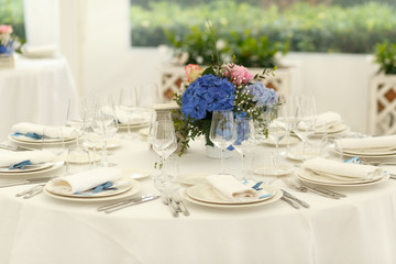 White serviettes and blue ribbons lie over the festive crockery