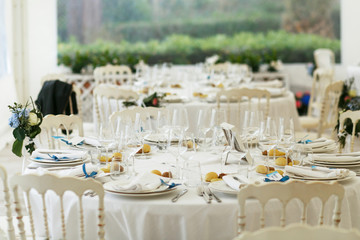 Plates with macaroons stand on the white dinner table