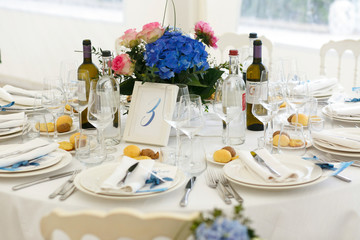 Bottles with alcohol stand on the dinner table served with white