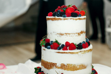 Pretty strawberries lie on different layers of wedding cake
