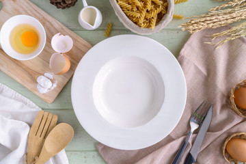 Empty dish with ingredients and equipment on green wooden table