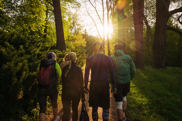 Group of friends walking with backpacks in sunset from back. Adventure, travel, tourism, hike and...