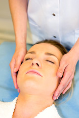 Detail of a woman face receiving a relaxing facial massage
