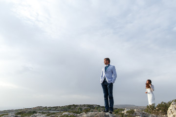 Man holds hands in his pockets while he stands on the field full
