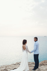 Man in blue suit admires a lady in dress with open gown standing