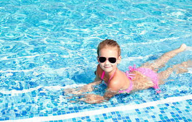 Fototapeta na wymiar Adorable smiling little girl in swimming pool