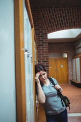 Stressed mature student standing in locker room