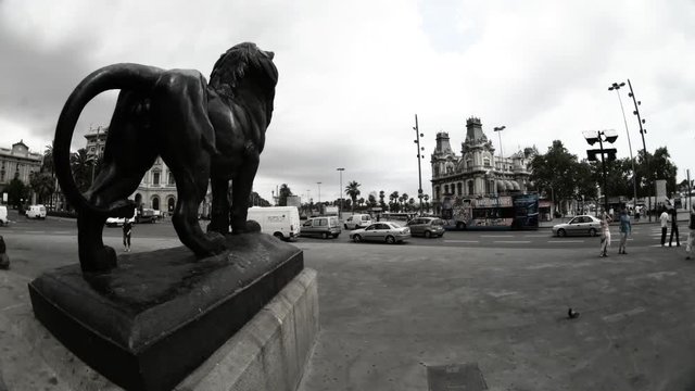 statue of a lion with traffic and people