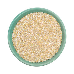 Dry oat bran hot cereal in a green bowl on a white background.