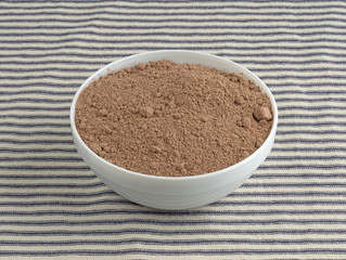Devil's food cake mix in a bowl atop a striped tablecloth.