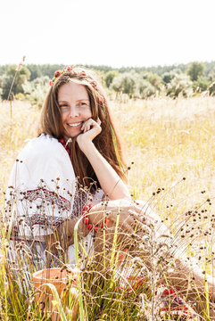 Pretty ukrainian woman dressed in embroidered clothes in the field