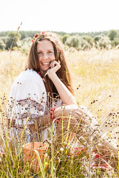 Pretty ukrainian woman dressed in embroidered clothes in the field