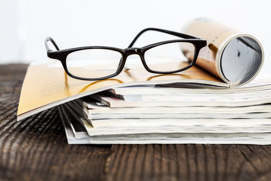 Magazines on table with eyeglasses