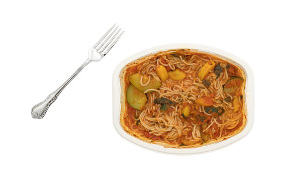 Angel hair pasta with zucchini and spinach with fork on a white background