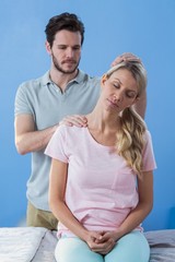 Physiotherapist stretching neck of a female patient