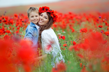 Beautiful woman with son in a red flowers field 