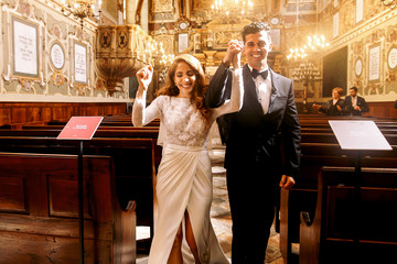 Happy newlyweds walk out like the winners of synagogue