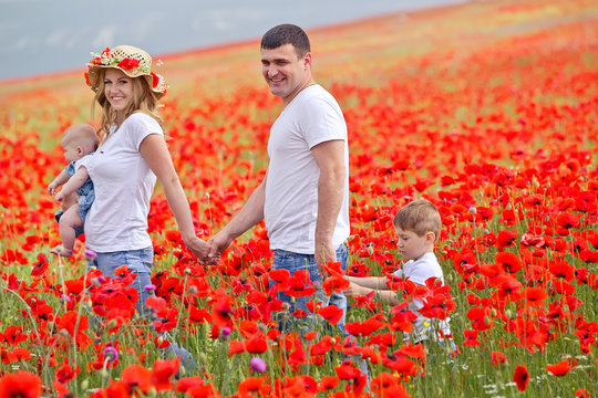 Happy Family In A Red Flowers Field 