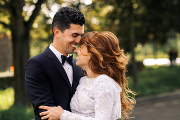 Golden waves of bride's hair cover her face while she hugs groom