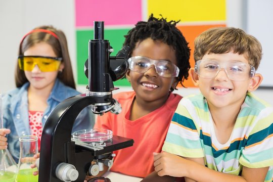 Kids doing experiment on microscope in laboratory