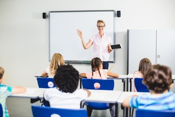 Teacher teaching kids on digital tablet