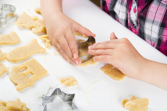 Children's hands knead the dough for baking cookies