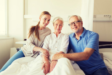 happy family visiting senior woman at hospital
