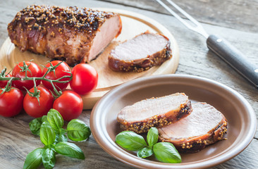 Baked pork meat wrapped in bacon