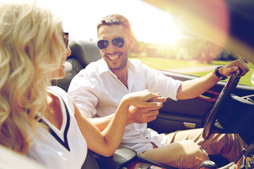 happy man and woman driving in cabriolet car