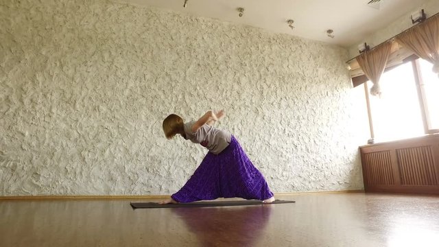 The young blonde girl practicing yoga in the hall. Asana on the balance. 4K