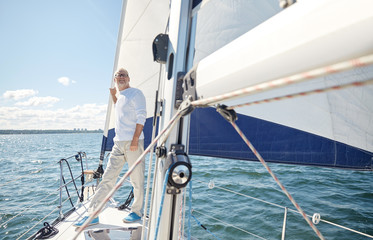 senior man on sail boat or yacht sailing in sea