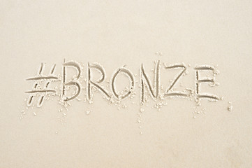 Hashtag social media message for bronze medal, sport's third place, written in sand on the beach in Rio de Janeiro, Brazil