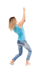 back view of standing girl pulling a rope from the top or cling to something. girl  watching. Rear view people collection.  backside view of person.  Isolated over white background. blonde in a blue
